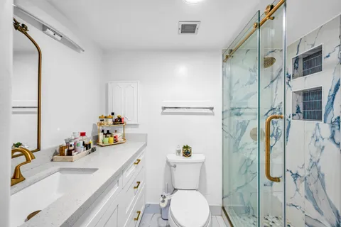 a bathroom with a sink mirror vanity and toilet
