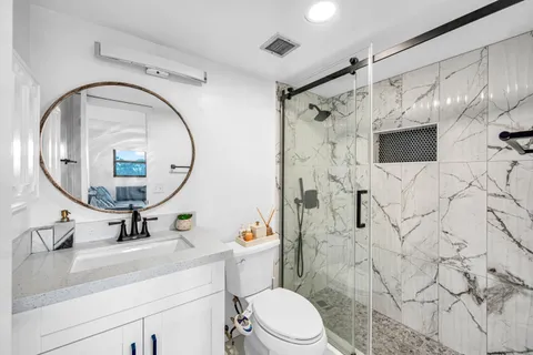 a bathroom with a sink a toilet and a mirror