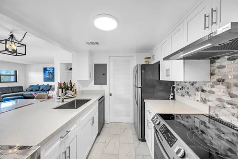 a kitchen with stainless steel appliances a sink stove and cabinets
