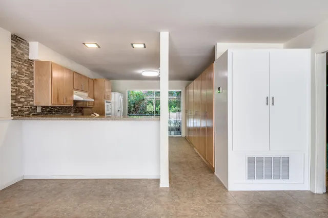 a kitchen with stainless steel appliances granite countertop a refrigerator and a large window