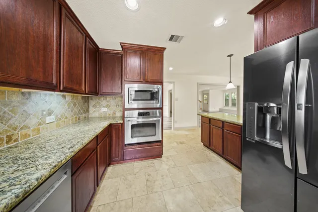 a kitchen with stainless steel appliances granite countertop a refrigerator stove and oven