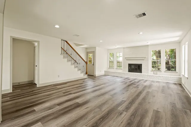 a view of empty room with wooden floor and fireplace