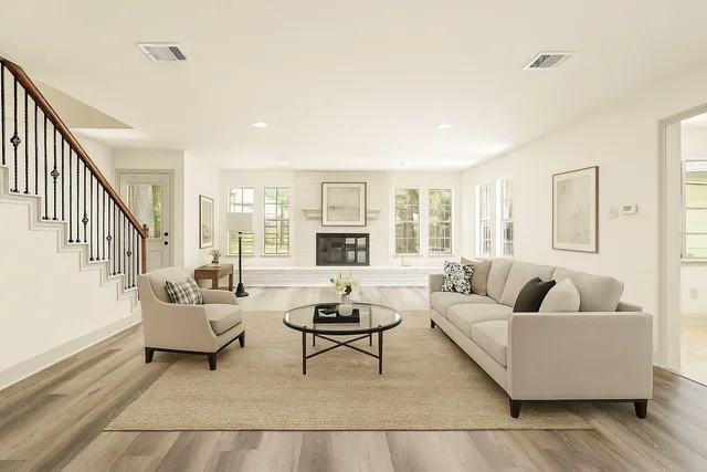 a living room with fireplace furniture and a rug