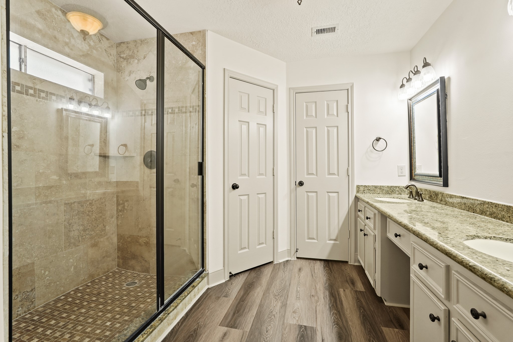 17606 Rustington Drive Spring, TX 77379 - Photo 26 of 44 a spacious bathroom with a granite countertop sink a mirror a shower and a bathtub