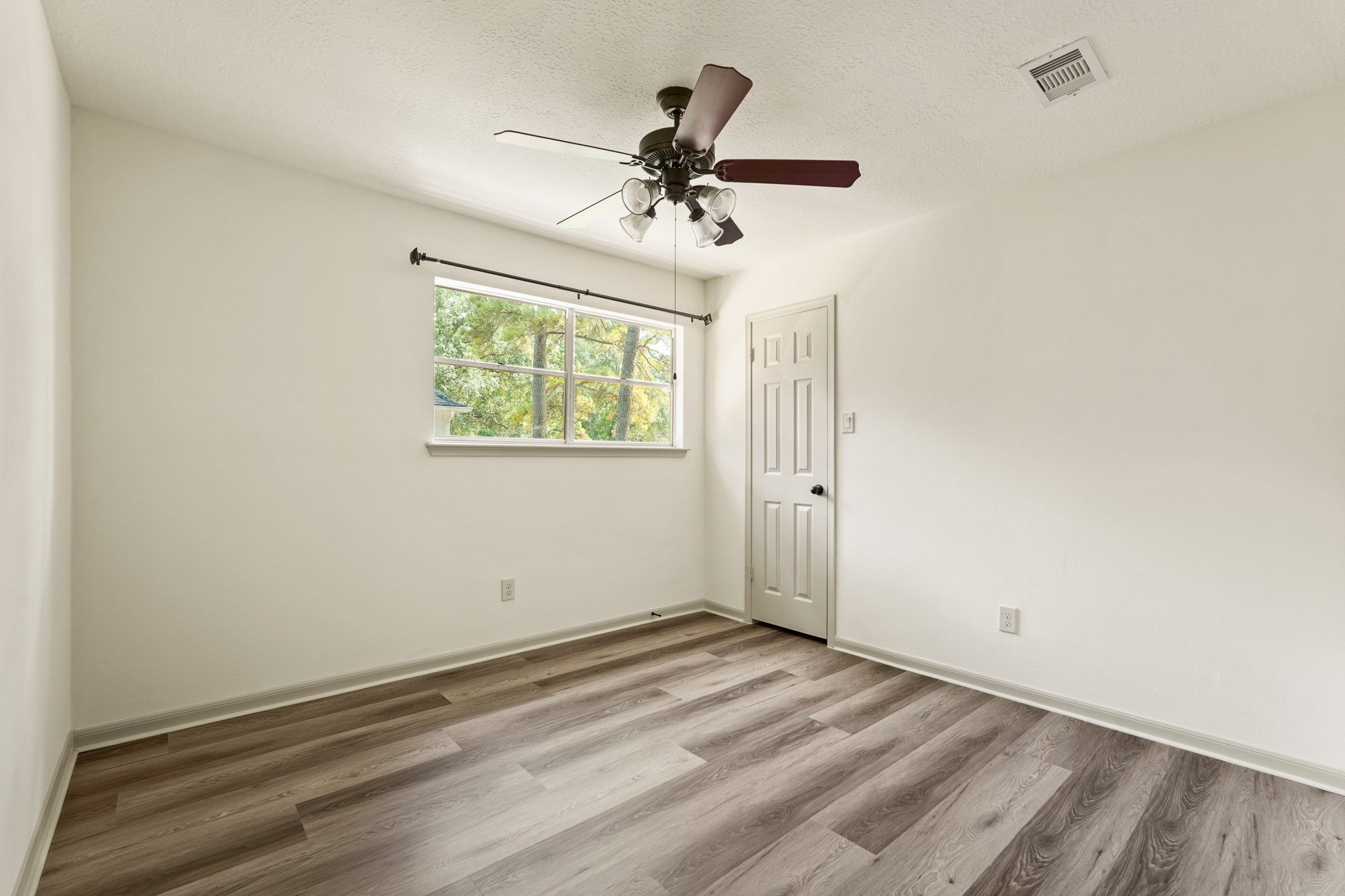 17606 Rustington Drive Spring, TX 77379 - Photo 29 of 44 an empty room with wooden floor ceiling fan and window