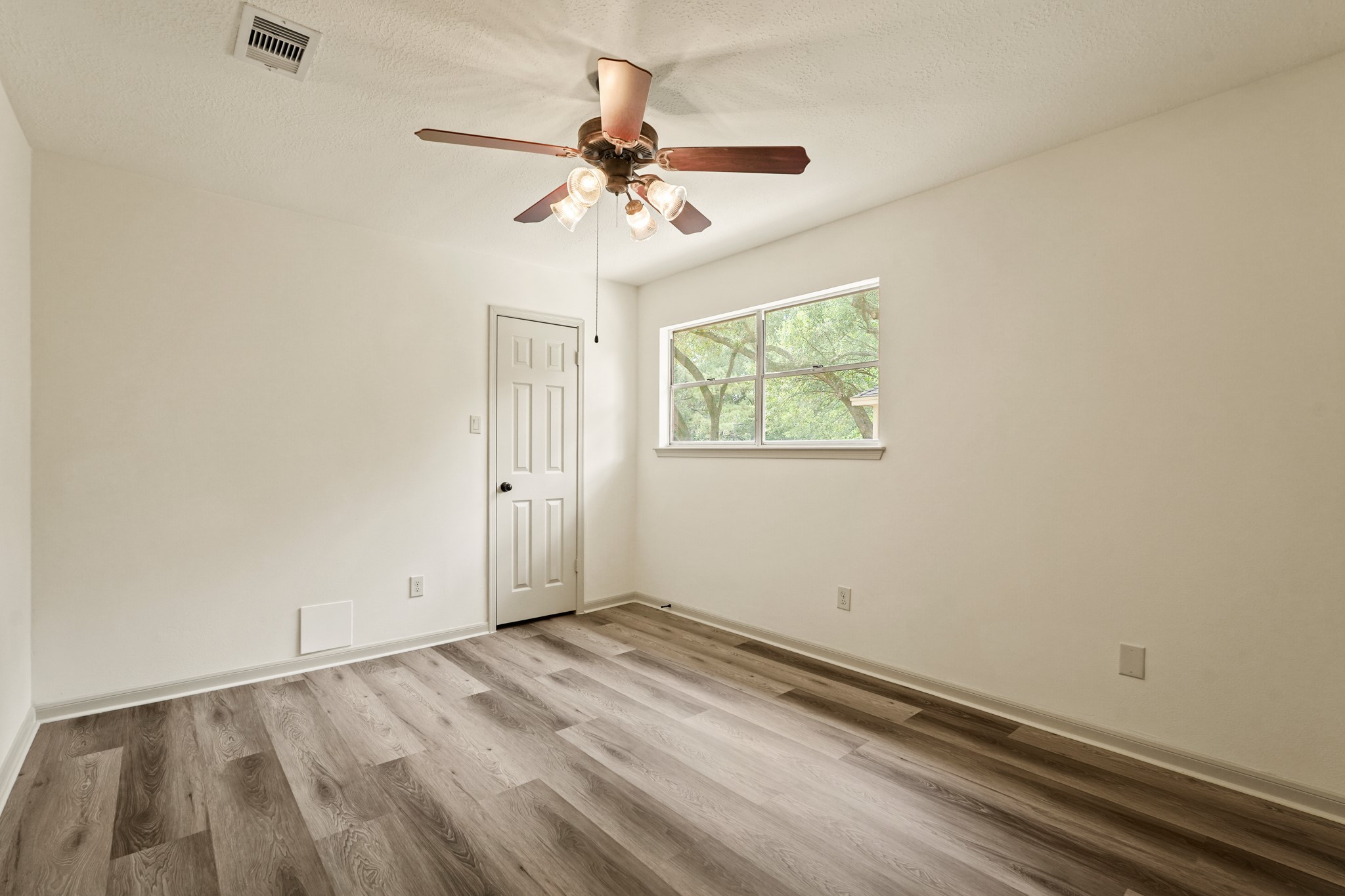 17606 Rustington Drive Spring, TX 77379 - Photo 32 of 44 an empty room with wooden floor fan and windows