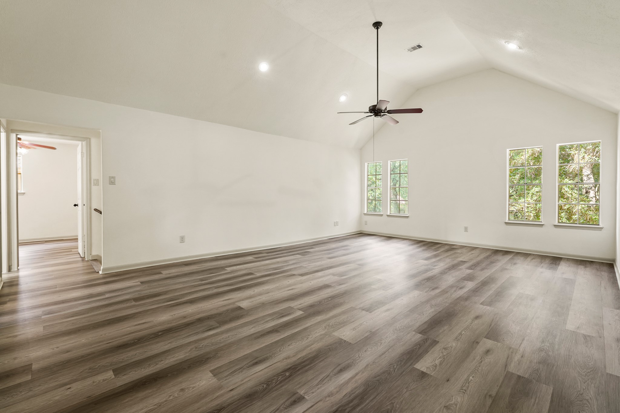 17606 Rustington Drive Spring, TX 77379 - Photo 33 of 44 an empty room with wooden floor windows and ceiling fan