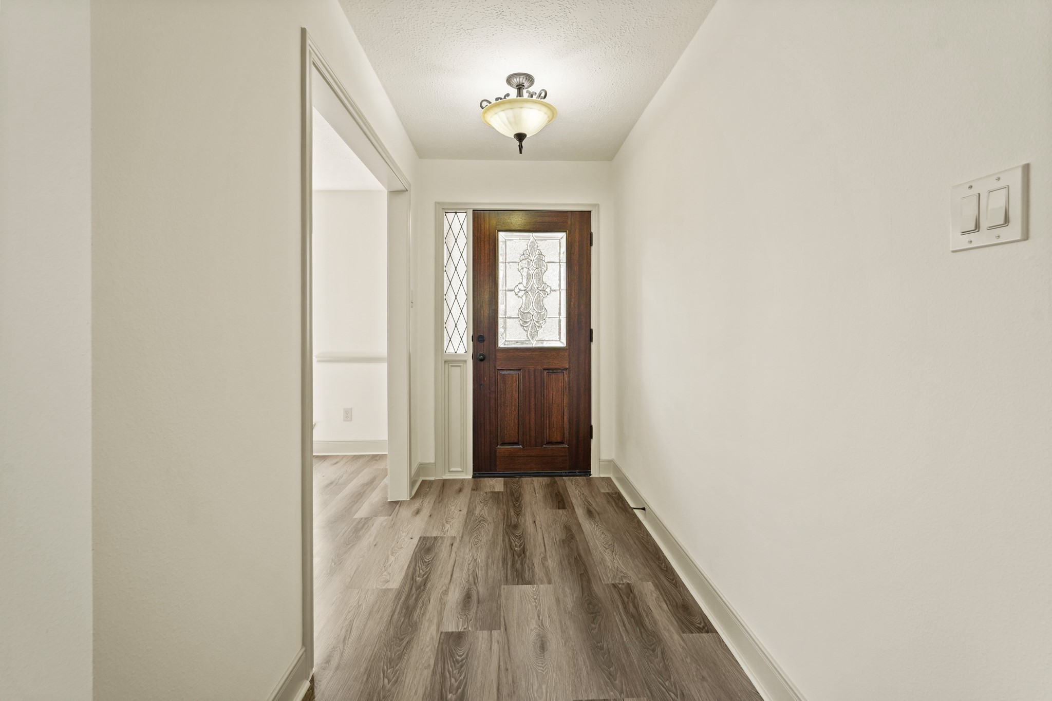 17606 Rustington Drive Spring, TX 77379 - Photo 6 of 44 a view of a hallway with wooden floor and a bathroom