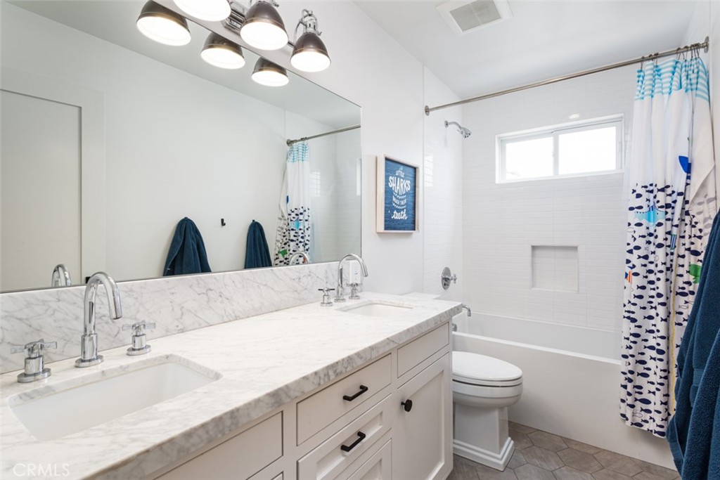 620 Gary Place Newport Beach, CA 92663 - Photo 25 of 36 a bathroom with a granite countertop sink a large mirror a toilet and a window