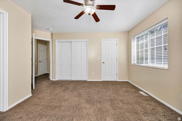2 West 1780 North Logan, UT 84341 - Photo 12 of 24 Unfurnished bedroom with dark colored carpet, a closet, and a ceiling fan