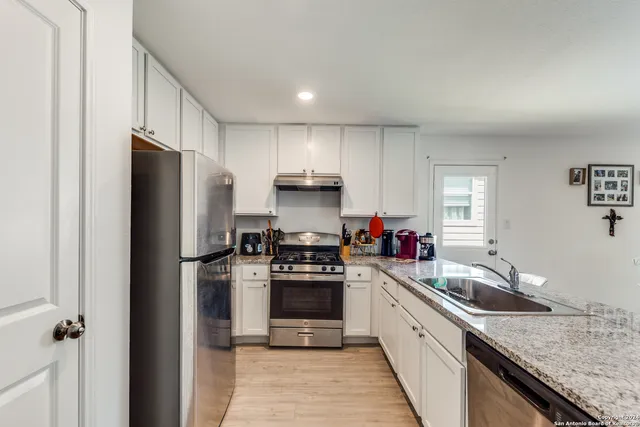 a kitchen with a sink a refrigerator and cabinets