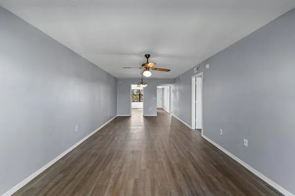 an empty room with a window and a fan