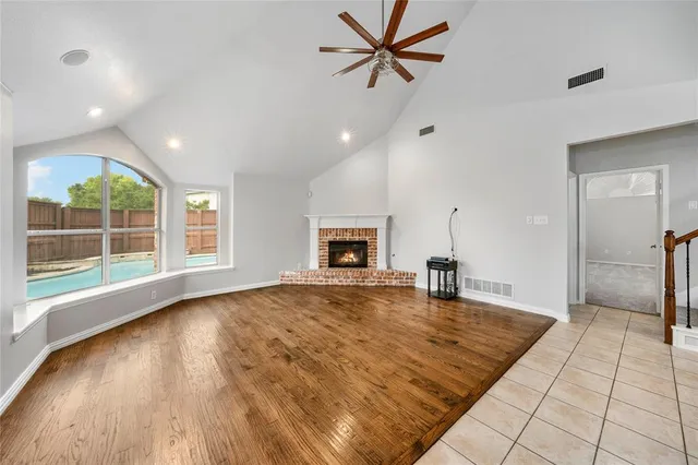 a big room with wooden floor and a fireplace