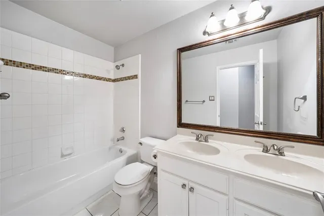 a bathroom with a sink a toilet a mirror a bathtub and shower