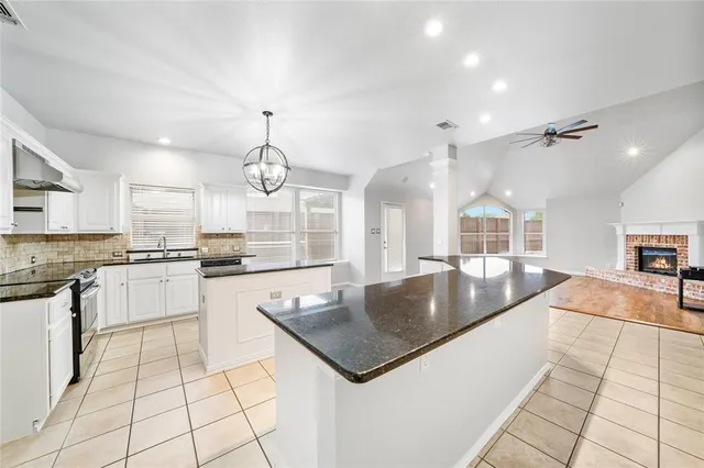 a large kitchen with granite countertop a sink a counter and appliances