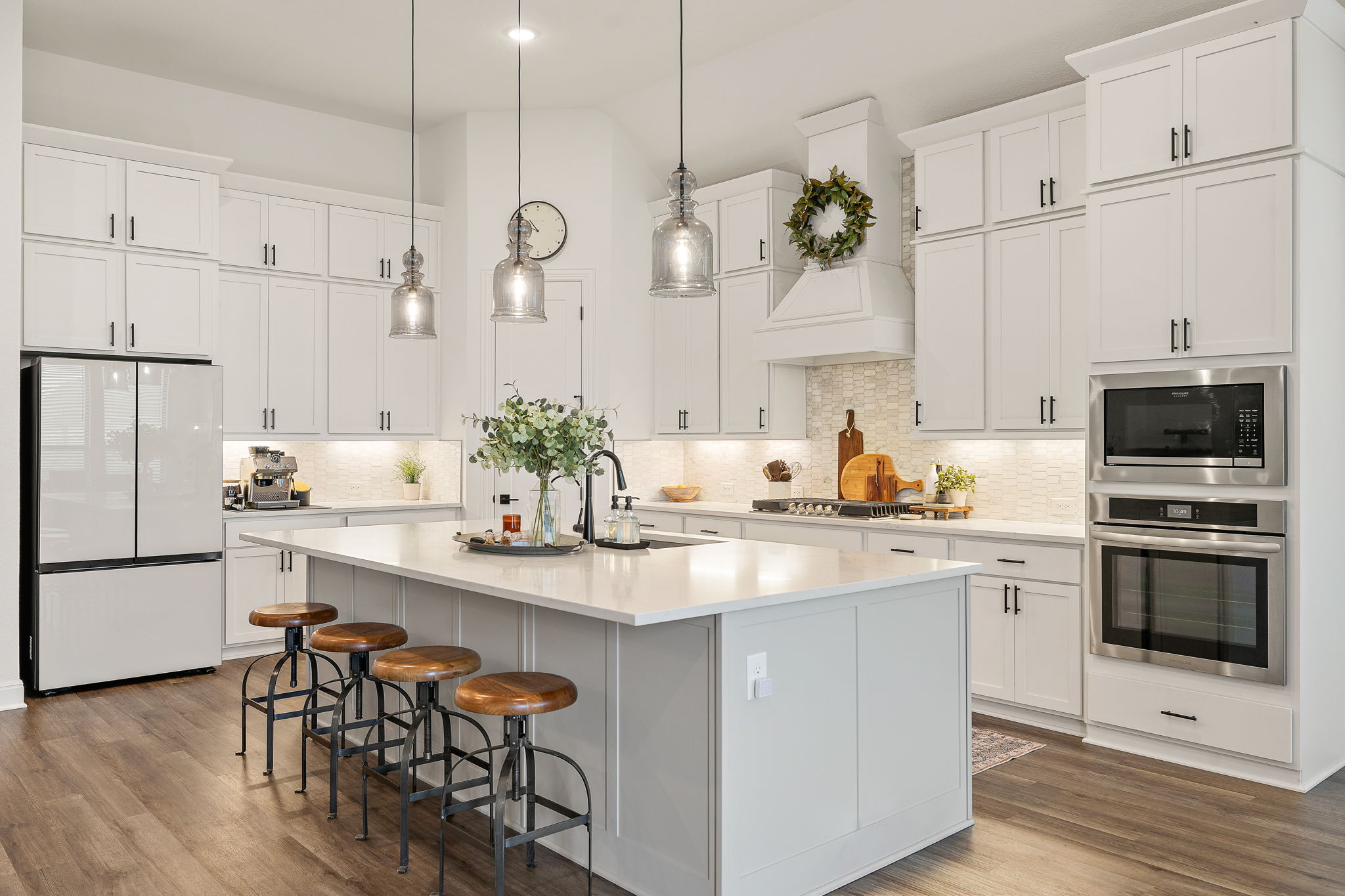 181 Constitution Way Kyle, TX 78640 - Photo 11 of 32 a kitchen with white cabinets stainless steel appliances and wooden floor