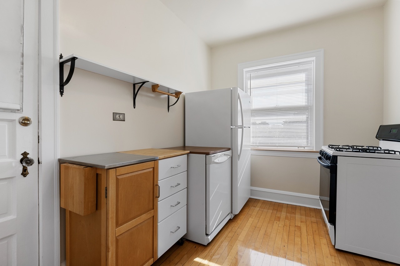 816 Mulford Street, Unit 2R Evanston, IL 60202 - Photo 5 of 13 a kitchen with white cabinets and white appliances