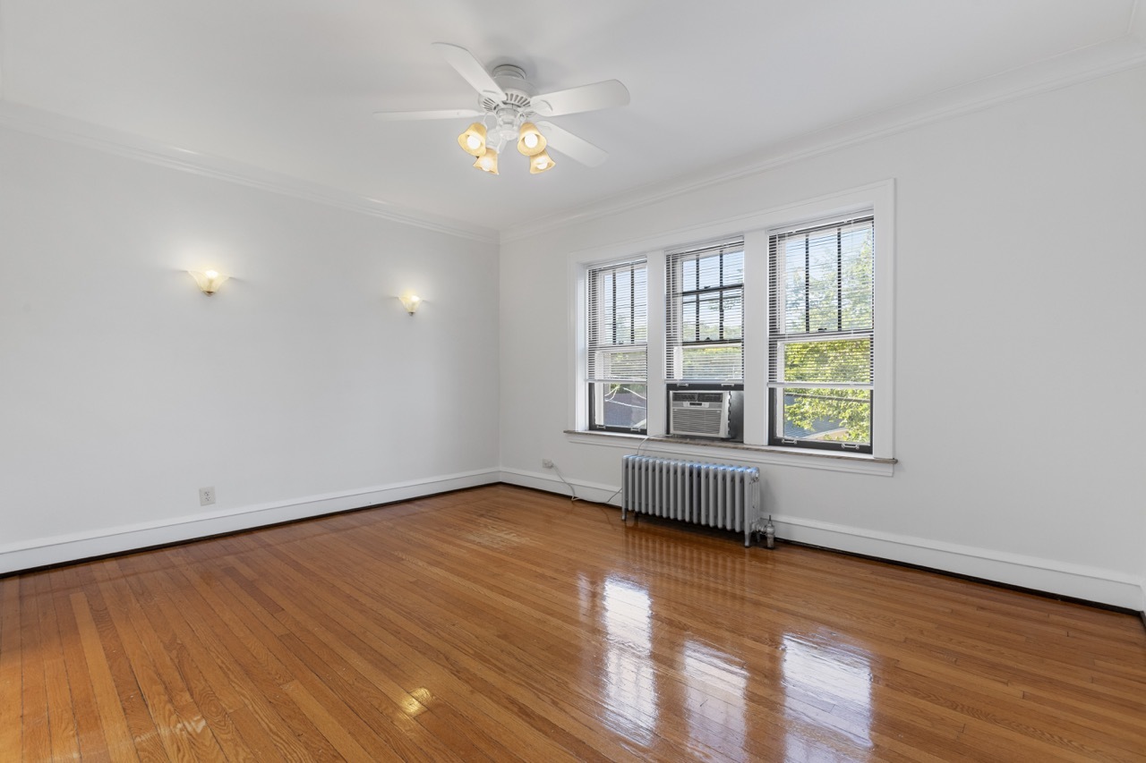 816 Mulford Street, Unit 2R Evanston, IL 60202 - Photo 7 of 13 an empty room with wooden floor and windows
