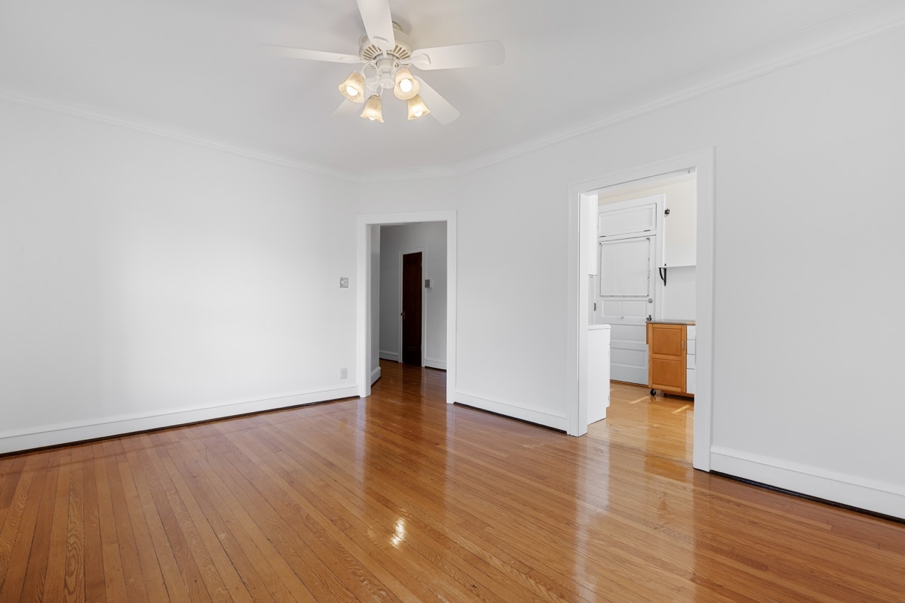 816 Mulford Street, Unit 2R Evanston, IL 60202 - Photo 8 of 13 an empty room with wooden floor and ceiling fan