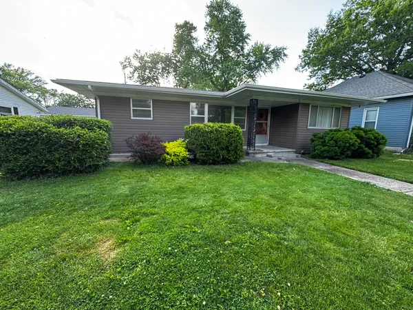 a view of a house with a yard and potted plants