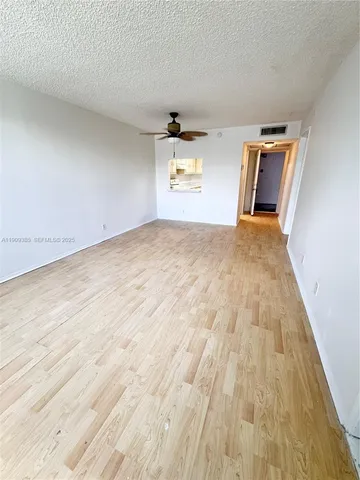 a view of empty room with wooden floor
