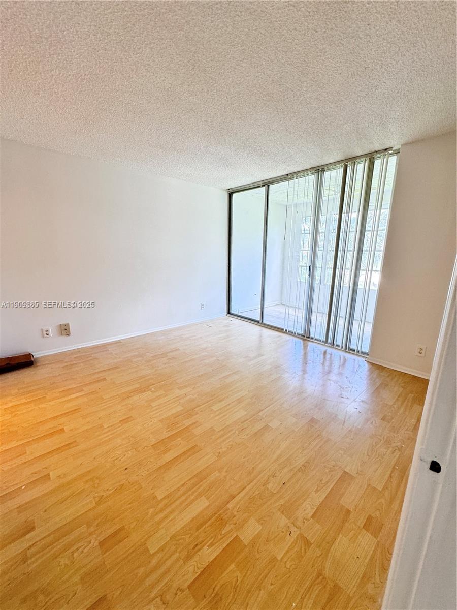 9441 Evergreen Place, Unit 206 Davie, FL 33324 - Photo 3 of 11 a view of an empty room with wooden floor