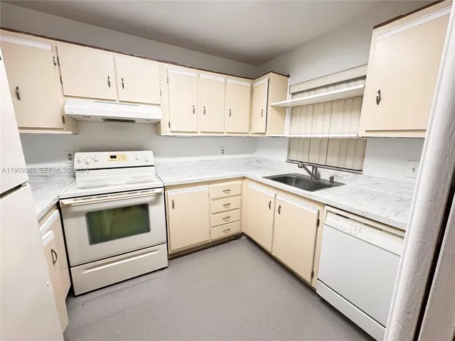 a kitchen with cabinets appliances and a sink