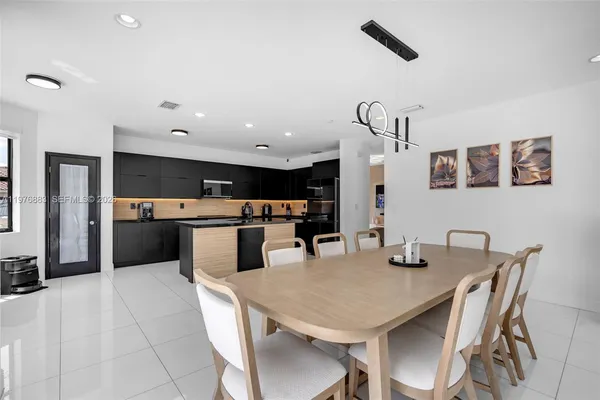 a kitchen with stainless steel appliances kitchen island granite countertop a refrigerator and a sink