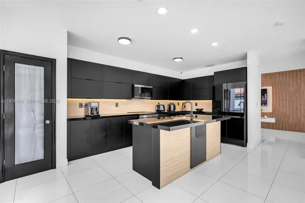a view of kitchen with stainless steel appliances kitchen island sink refrigerator and stove