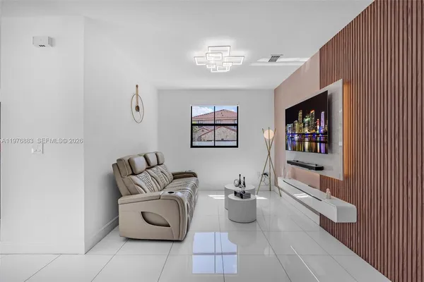 a bedroom with a bed and a flat tv screen on dresser