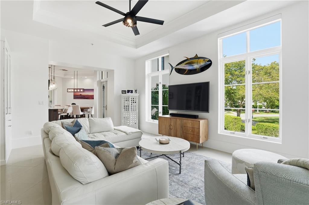 1008 7th Street South, Unit B1 Naples, FL 34102 - Photo 12 of 48 Living area featuring ceiling fan, tile patterned flooring, and a tray ceiling