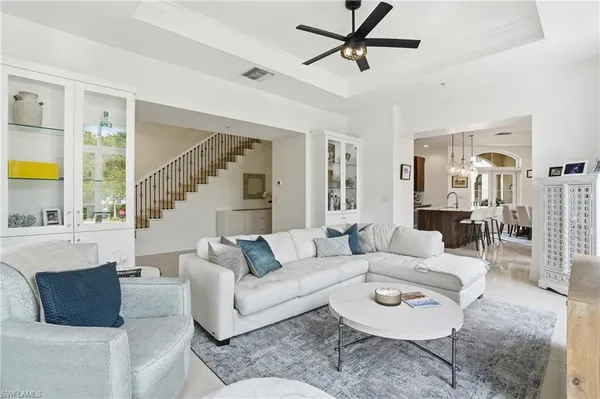 a living room with furniture a ceiling fan and a window