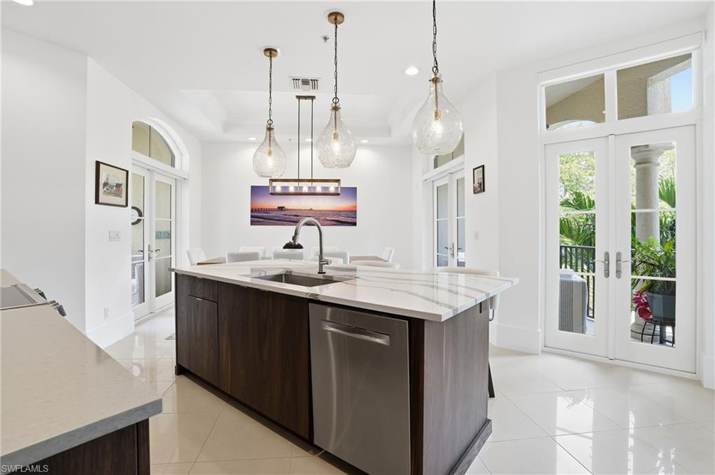 1008 7th Street South, Unit B1 Naples, FL 34102 - Photo 18 of 48 Kitchen with french doors, dark wood finish cabinets, modern cabinets, light stone counters, and dishwasher