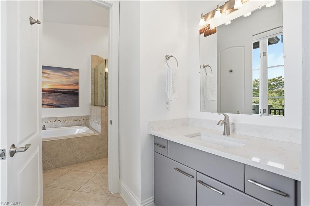 1008 7th Street South, Unit B1 Naples, FL 34102 - Photo 25 of 48 Full bathroom featuring vanity, a garden tub, and light tile patterned floors