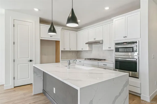 a kitchen with kitchen island a sink stainless steel appliances and cabinets