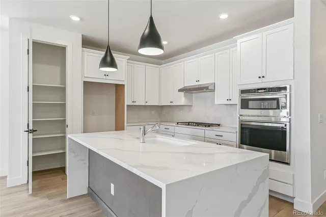 a kitchen with kitchen island a stove a sink and a refrigerator