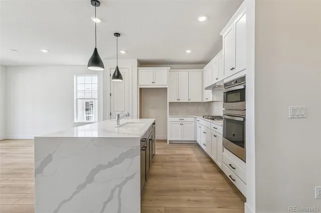 a kitchen with stainless steel appliances kitchen island granite countertop a sink and cabinets