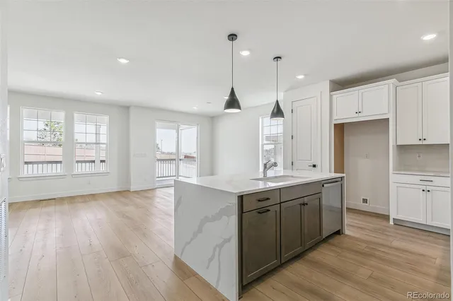 a large kitchen with stainless steel appliances granite countertop a sink a window and wooden floor