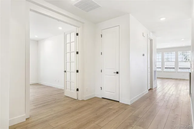 a view of a hallway with wooden floor and closet area