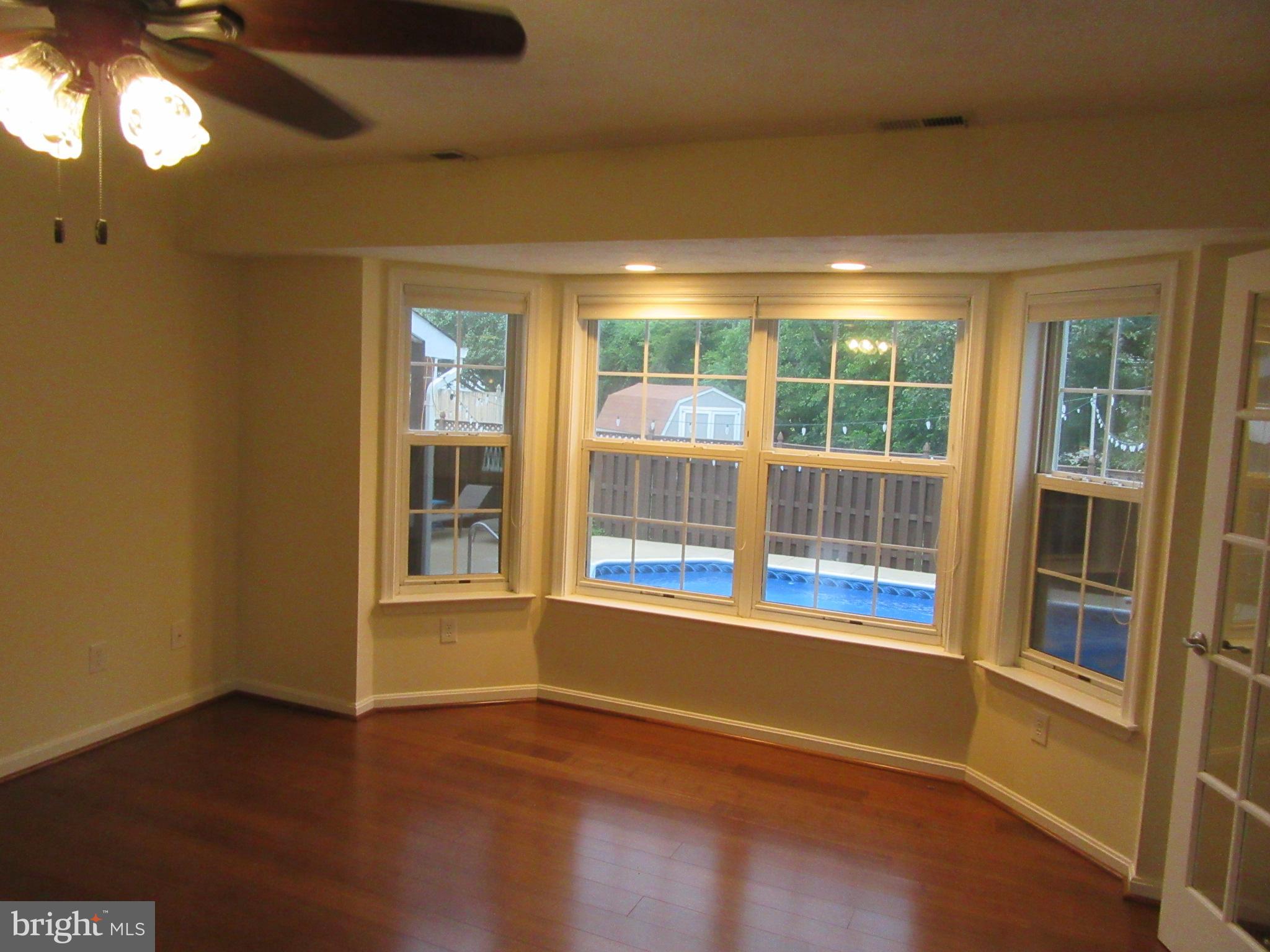 11905 Mill Bridge Road Lusby, MD 20657 - Photo 19 of 59 a view of empty room with wooden floor and fan