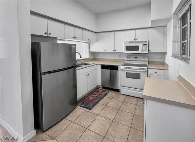 a kitchen with stainless steel appliances granite countertop a refrigerator sink stove and microwave