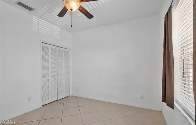 an empty room with chandelier fan