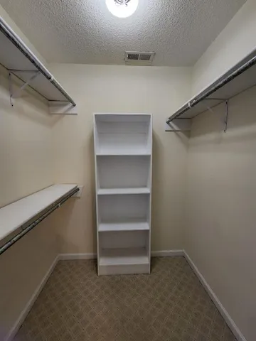a white toilet sitting next to a wooden cabinet