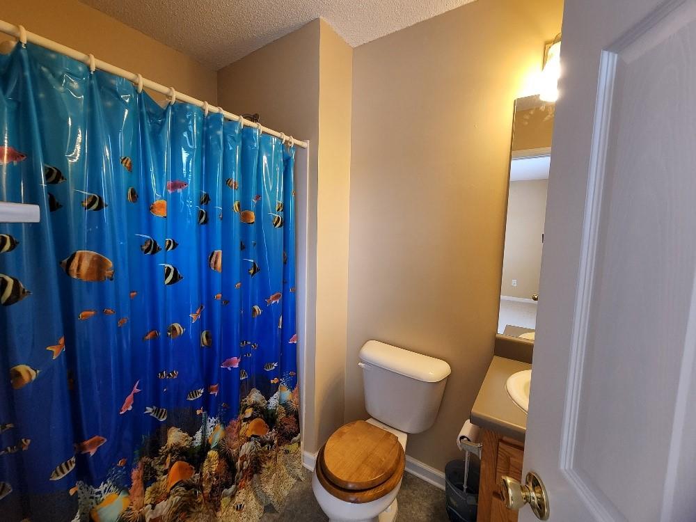 663 Elliott Drive Northwest Rome, GA 30165 - Photo 8 of 9 a white toilet sitting next to a wooden cabinet