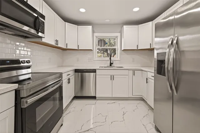 a kitchen with a refrigerator sink and cabinets