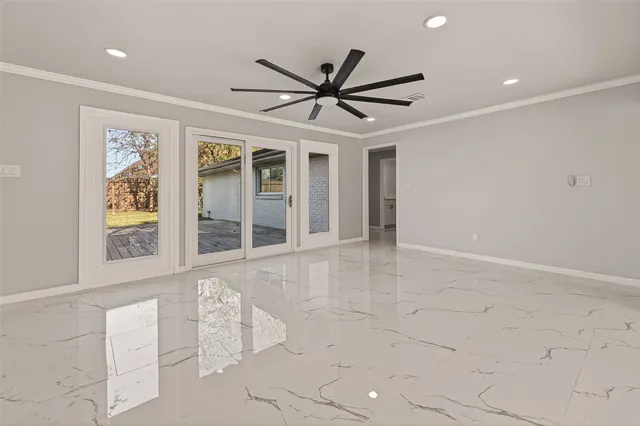 an empty room with windows and ceiling fan