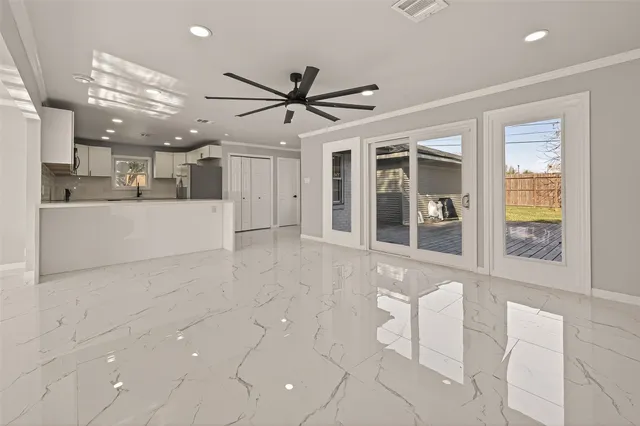 a view of a big room with a chandelier fan and windows