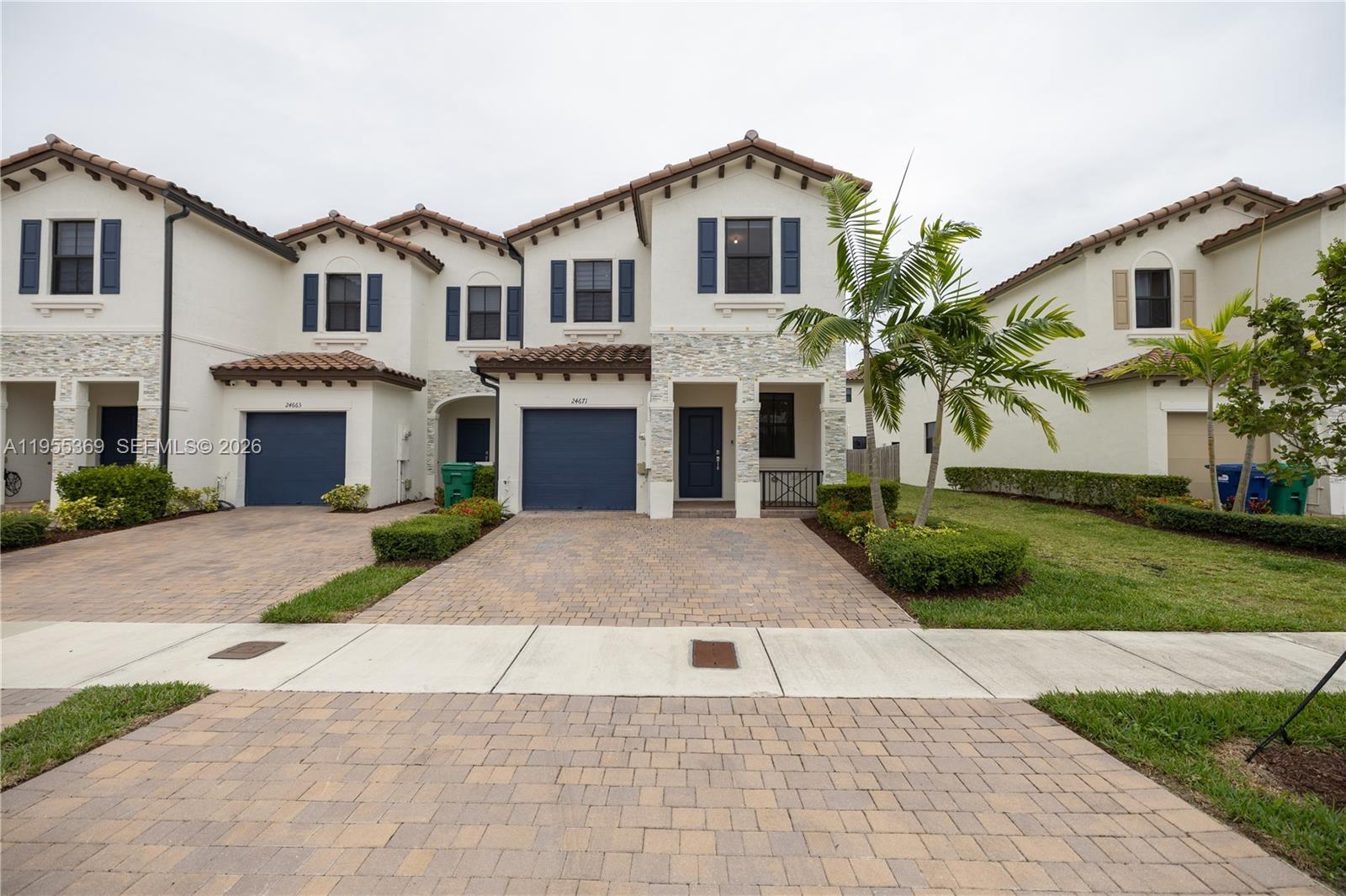 a front view of a house with a yard and trees