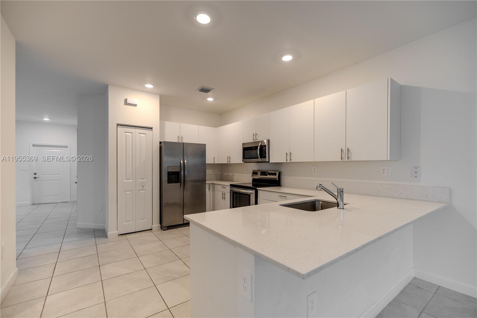 24671 Southwest 119th Place Homestead, FL 33032 - Photo 9 of 31 a kitchen with a refrigerator a sink and cabinets