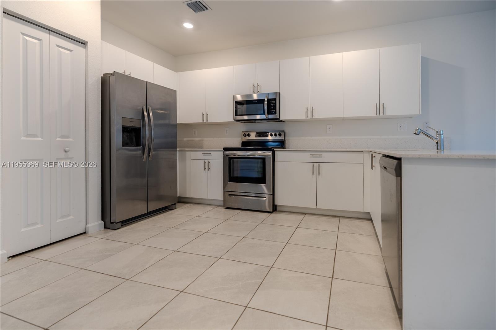 24671 Southwest 119th Place Homestead, FL 33032 - Photo 10 of 31 a kitchen with stainless steel appliances granite countertop a refrigerator and a stove top oven